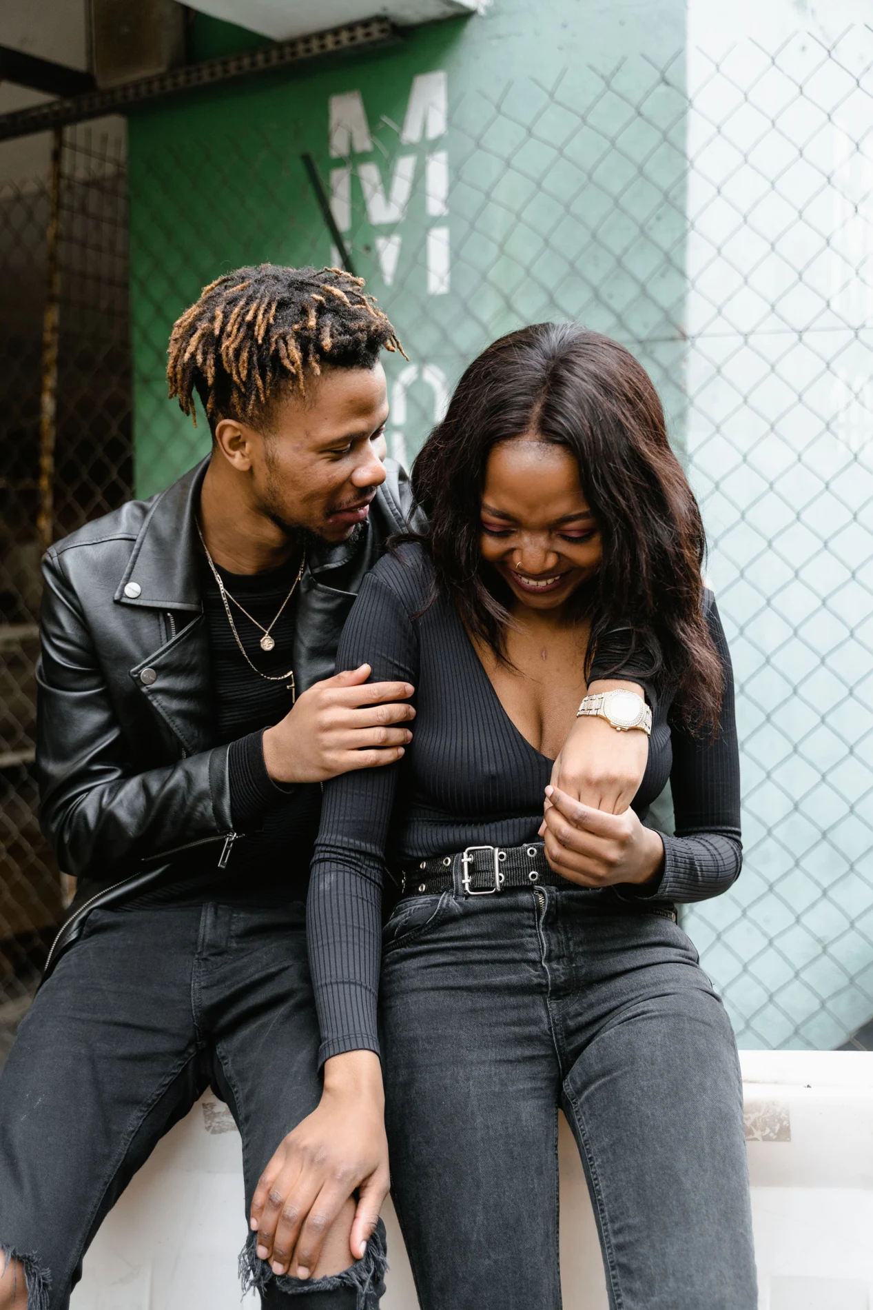 Two people laughing together on a city street