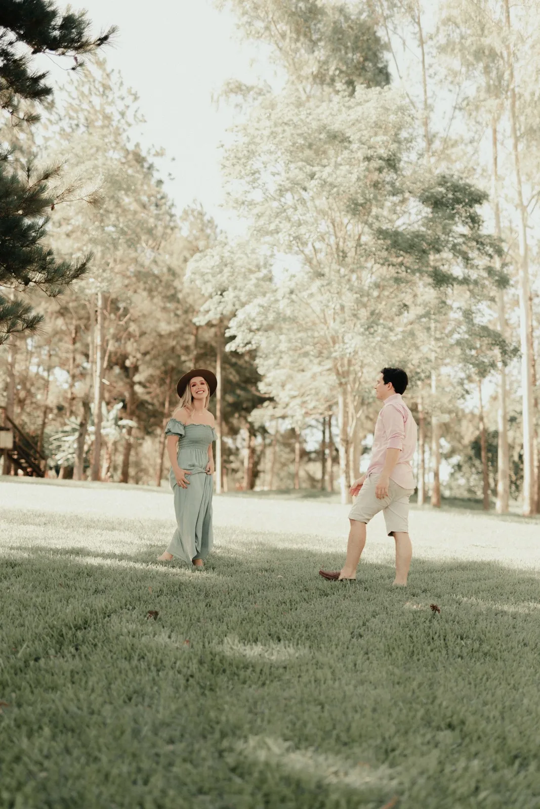 Couple walking casually in a lush green park, enjoying the natural surroundings.