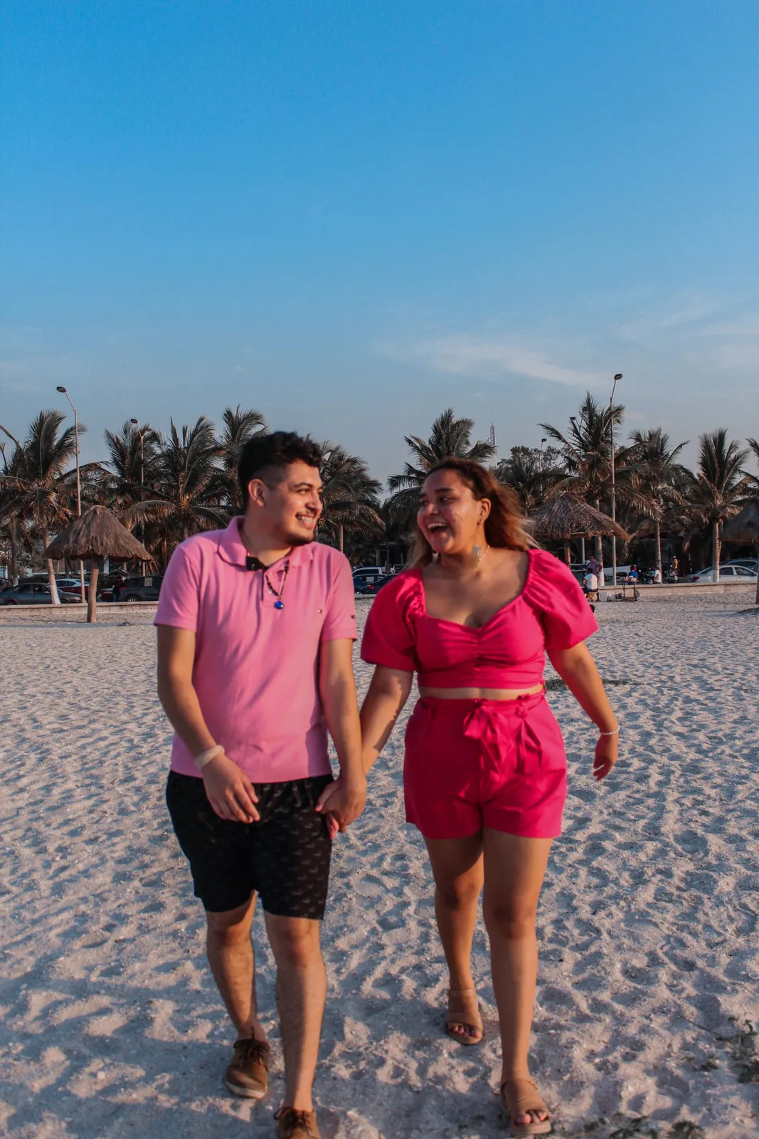 Happy couple walking hand in hand on a sunny beach enjoying each other's company.
