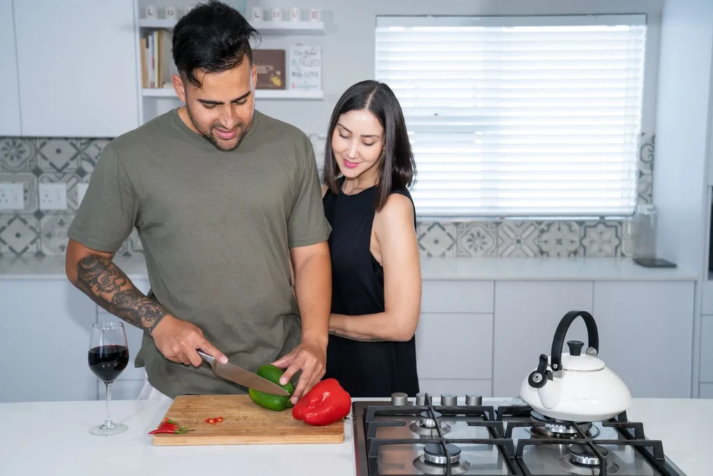 A couple enjoying cooking together in a bright, modern kitchen setting.