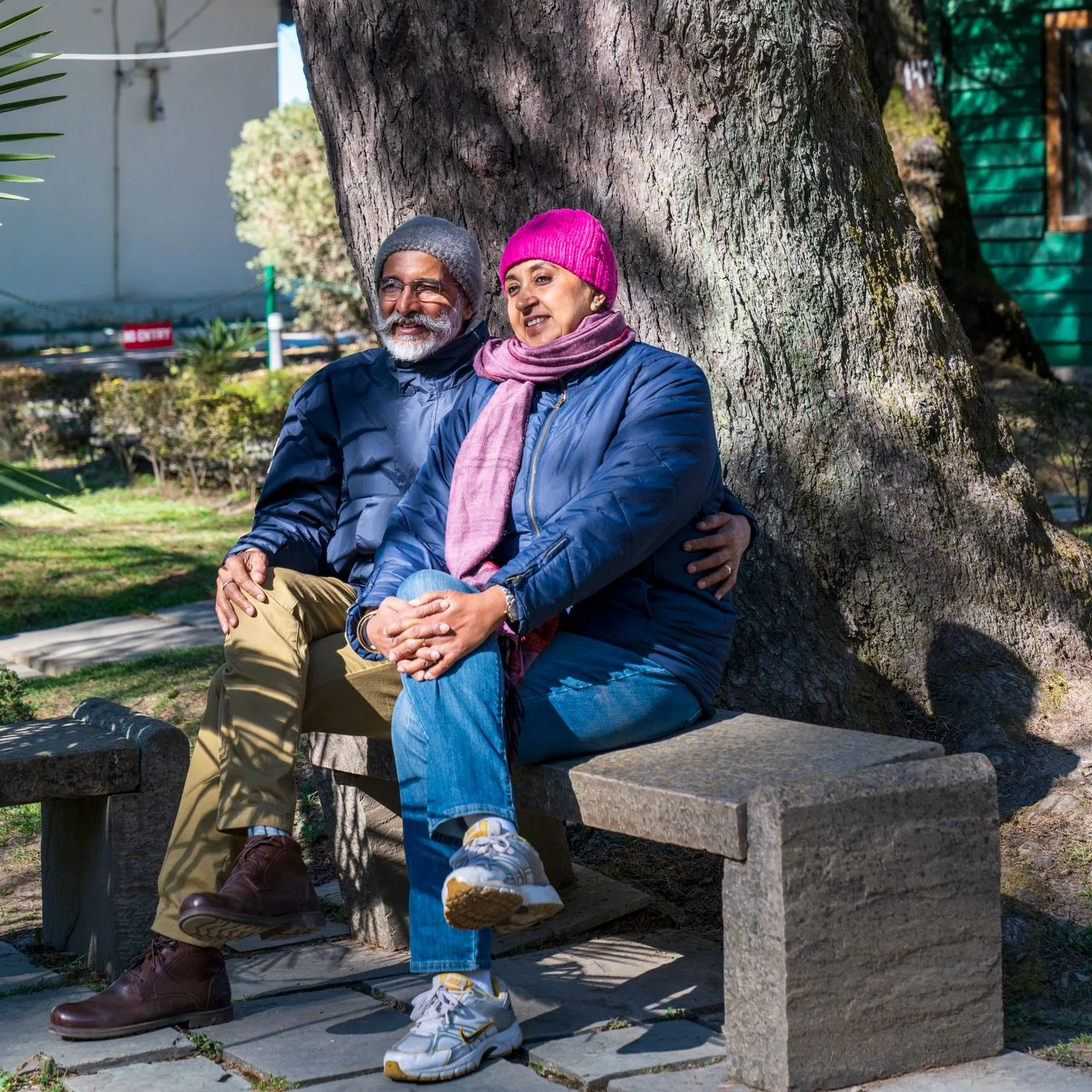 Happy senior couple sitting outdoors on a sunny winter day.