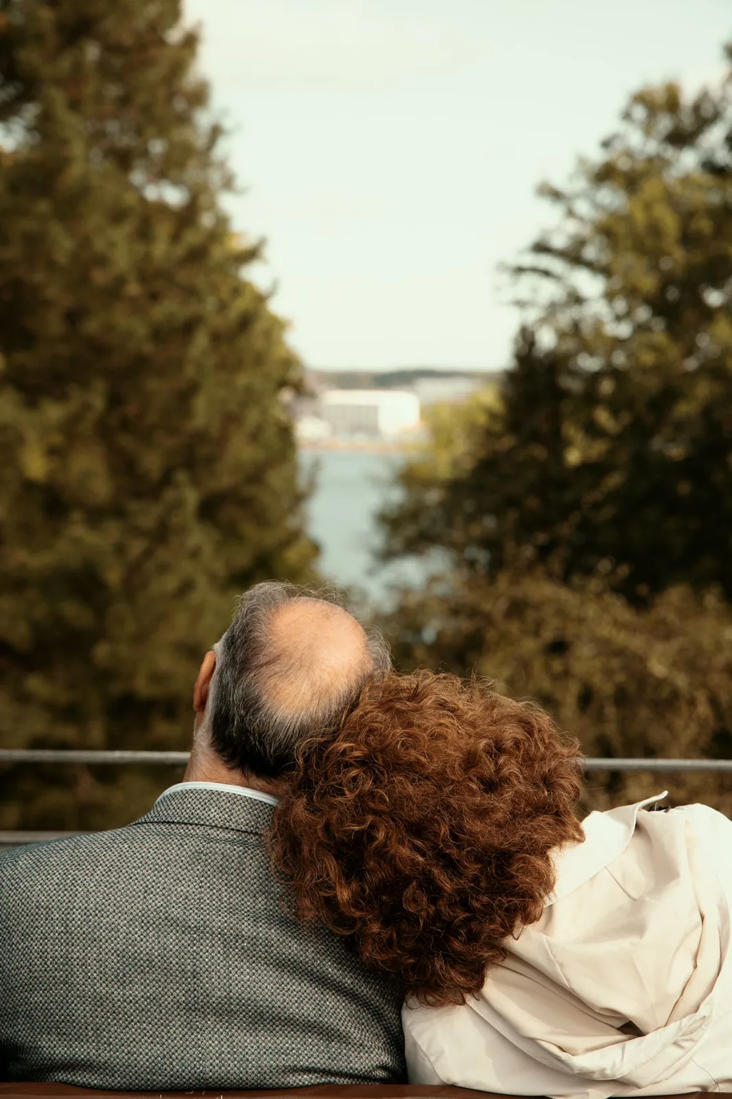 Senior couple sitting together, embracing nature's beauty outdoors.