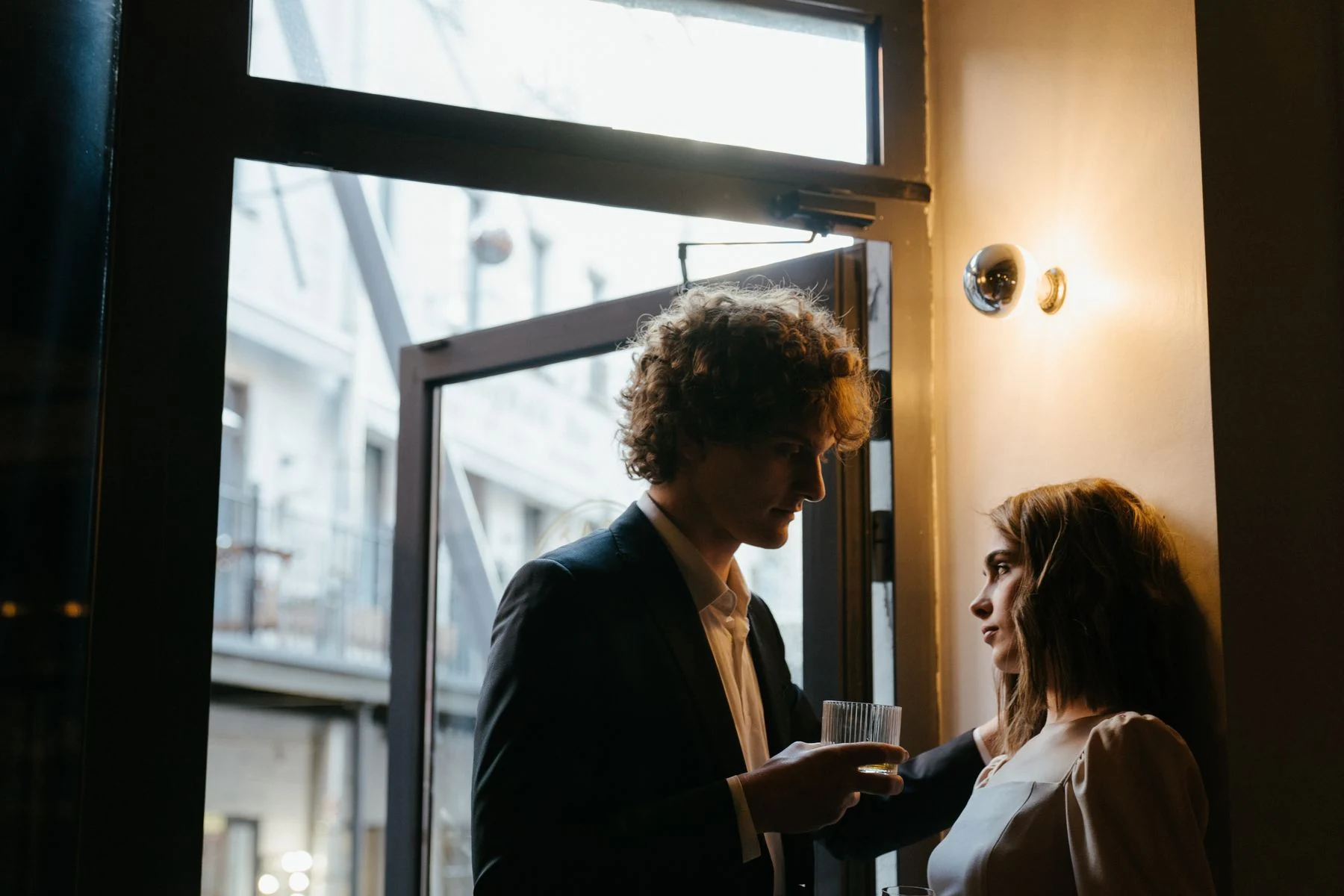 Two adults talking by a restaurant window