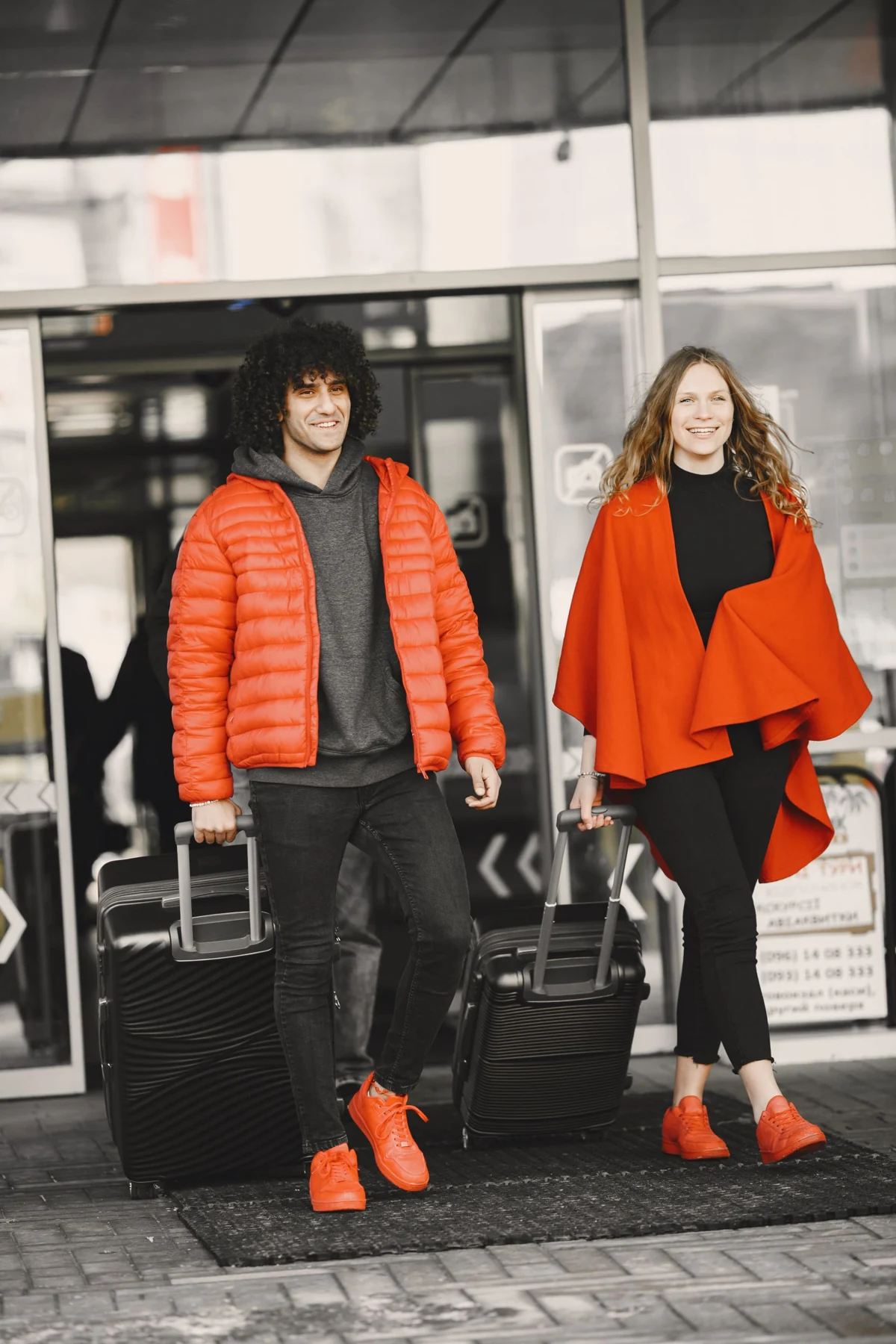 A couple leaving an airport together with luggage