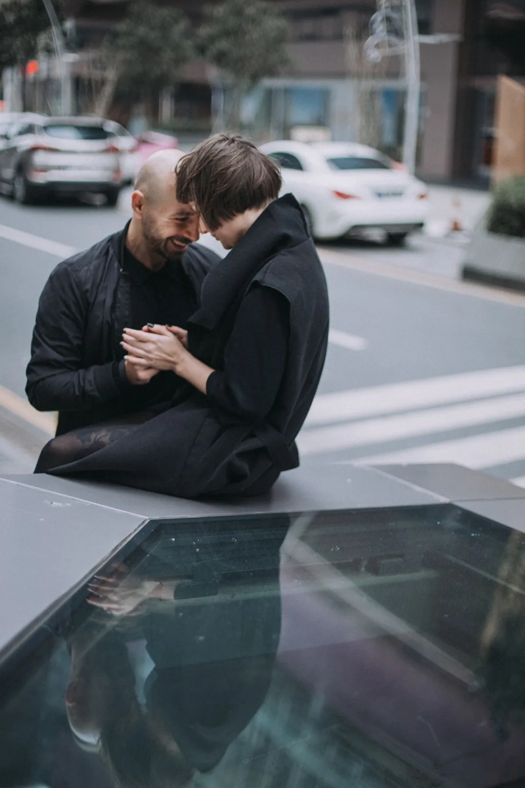 A loving couple embracing on a city street in Istanbul, capturing a moment of affection amidst urban life.