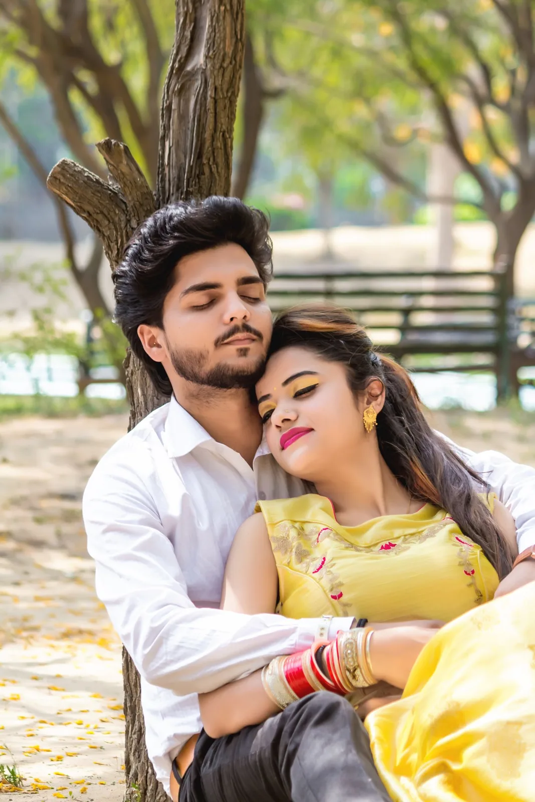 Romantic couple sitting together in a sunlit park, showing affection and peace.