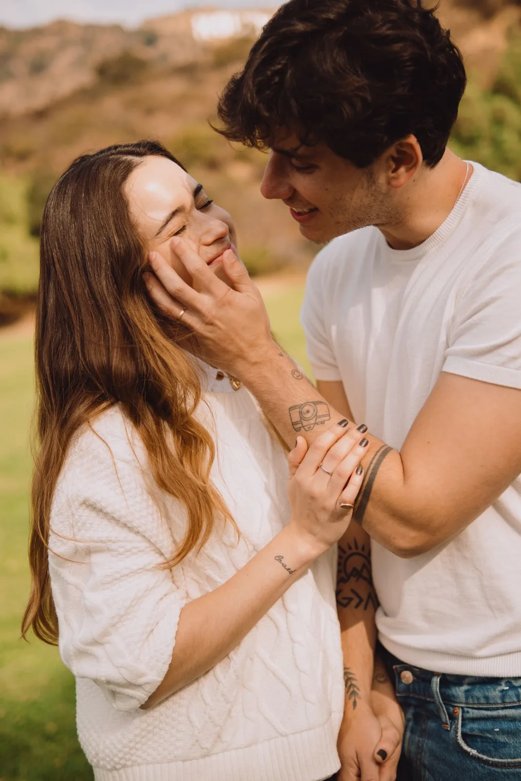 A loving couple shares a tender moment in a sunny Los Angeles park.