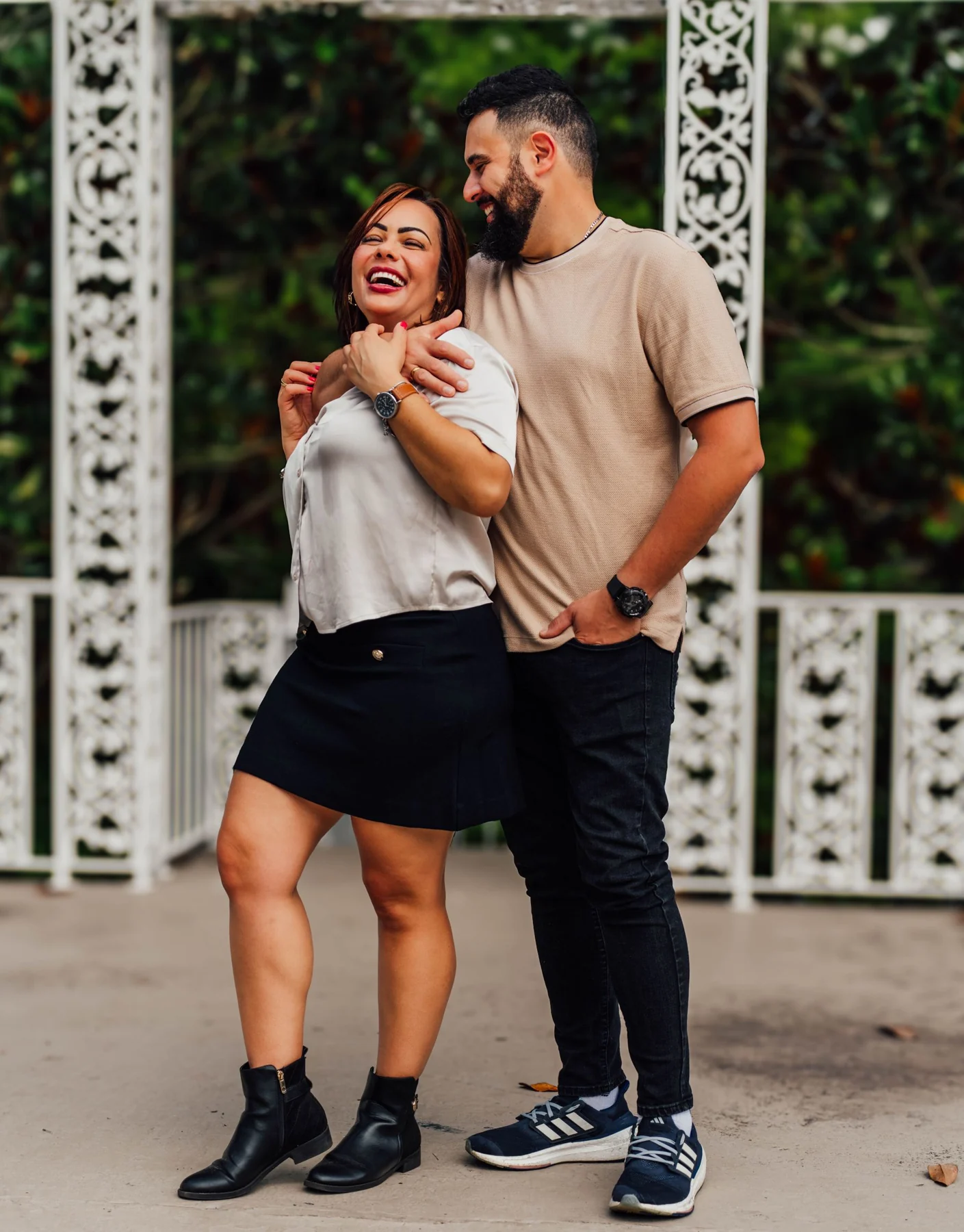 Joyful couple sharing a light moment in a charming outdoor setting, showcasing love and happiness.
