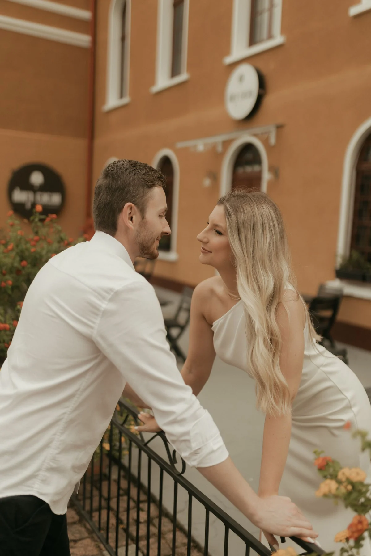 A couple enjoys a romantic moment at an outdoor cafe with a warm ambiance.