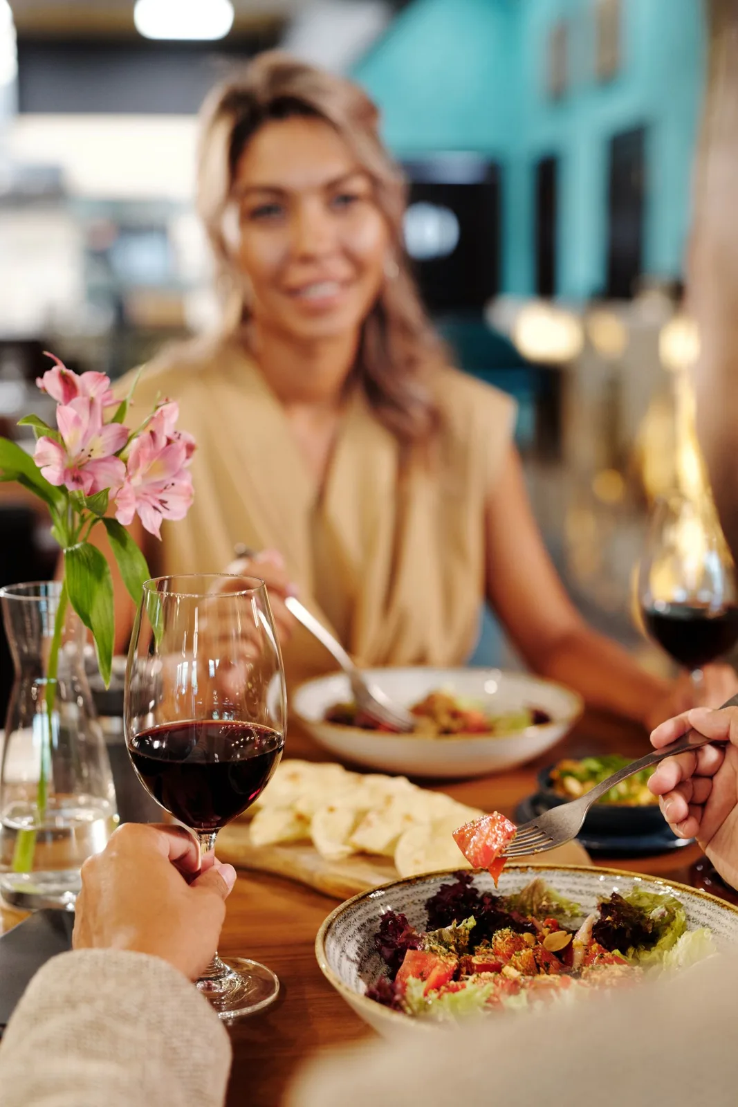 A couple enjoys a romantic dinner with wine and gourmet dishes in an elegant restaurant setting.