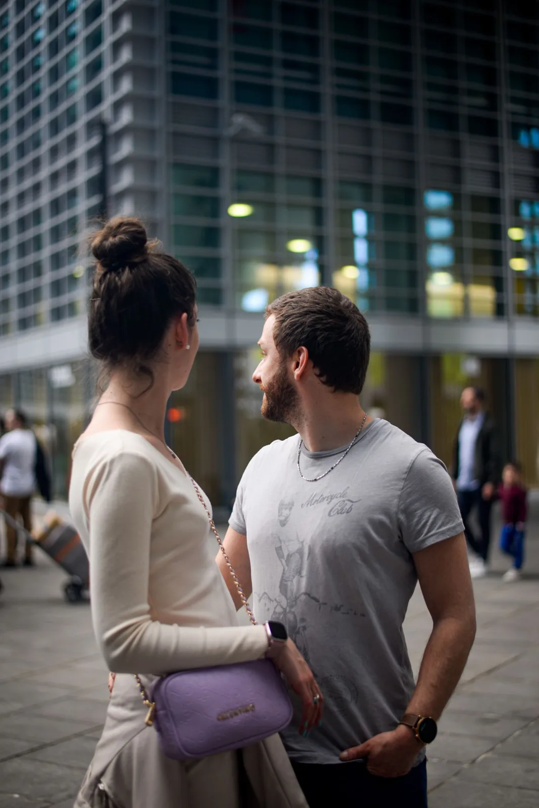 Stylish couple standing outside in Milan, capturing modern urban vibe.