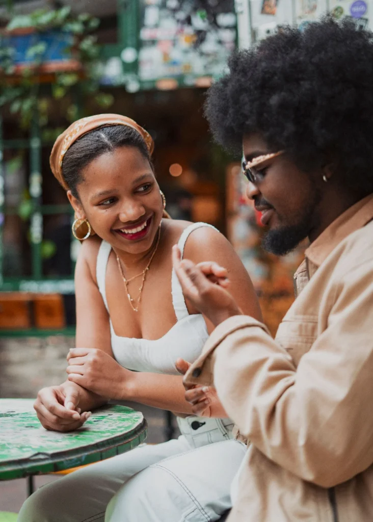 Smiling couple enjoying a cozy coffee date at an outdoor cafe in Budapest, Hungary.