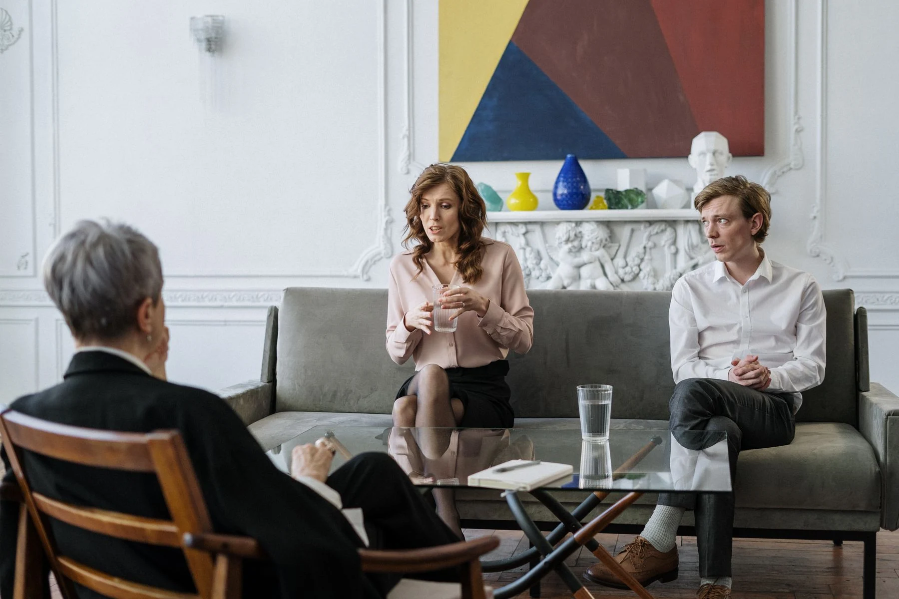 Two adults talking with a seated facilitator